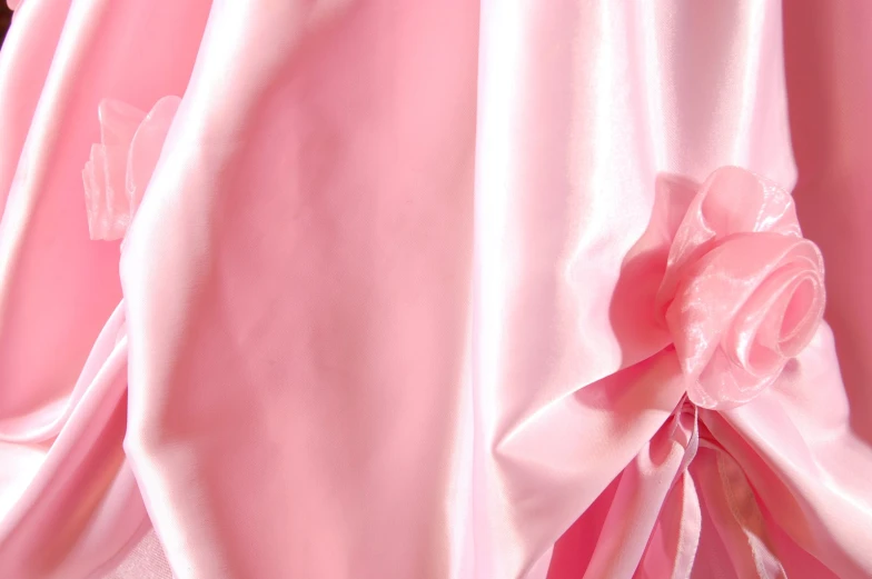 a pink flower and satin linings on top of a skirt