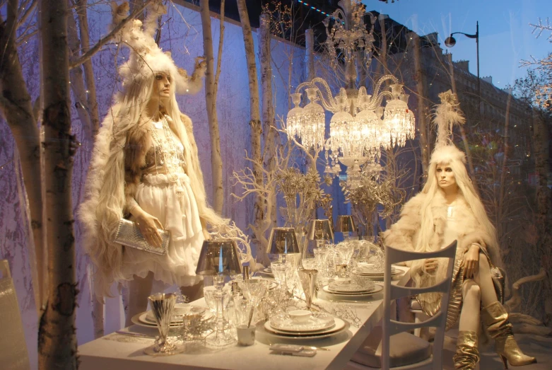 a snow wonderland themed table and set up with crystal chandelier and winter themed decorations