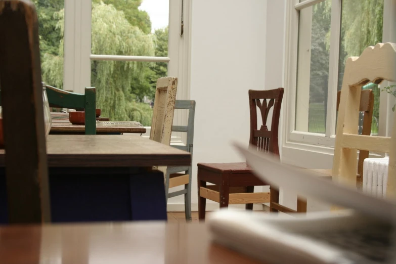 a dining table with four chairs next to a window