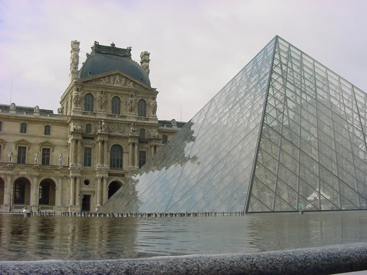 a large glass pyramid is in front of a building