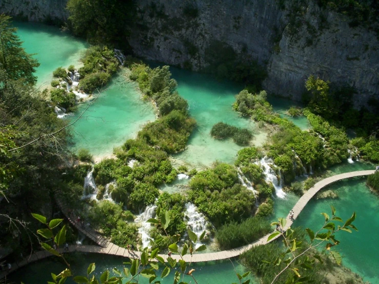 a beautiful view looking down on a bridge going to waterfalls