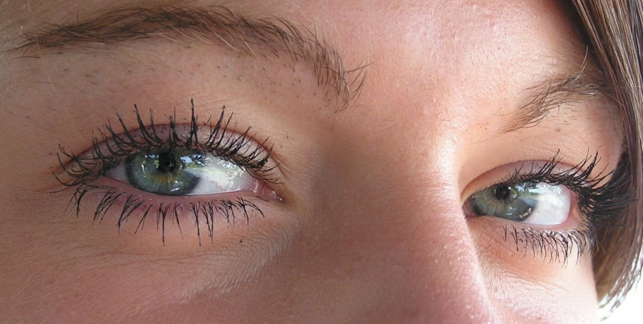 a woman with long lashes looking into the camera