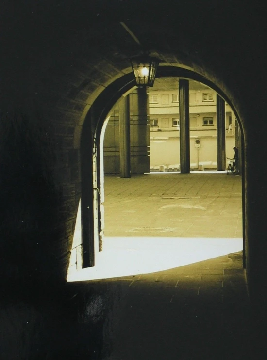 an archway over a cement walkway leading to the outside