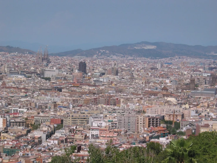 a cityscape, looking down on tall buildings and mountains