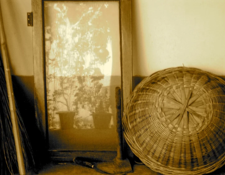 a basket sitting by a wooden door next to a fan