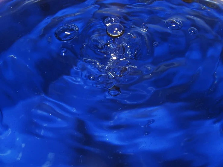 a liquid pouring from a large metal faucet into water