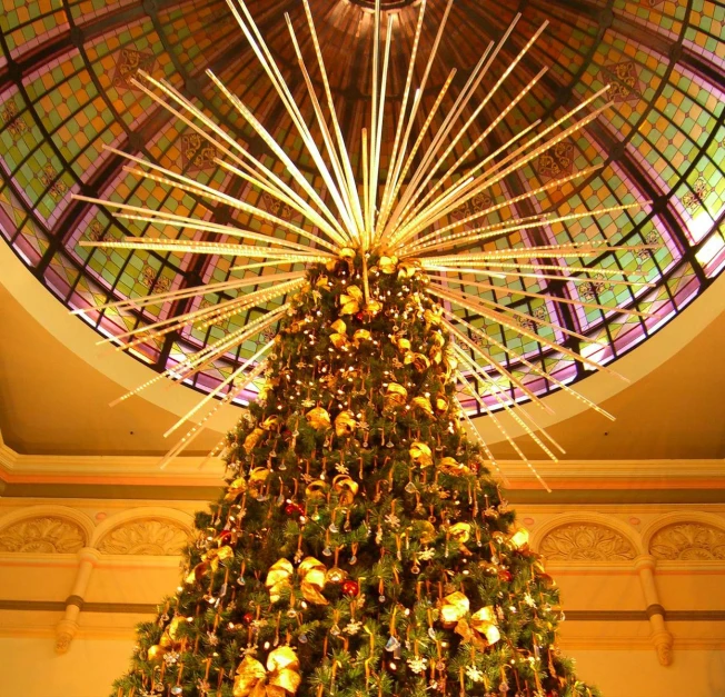 christmas tree is lit up in a large building