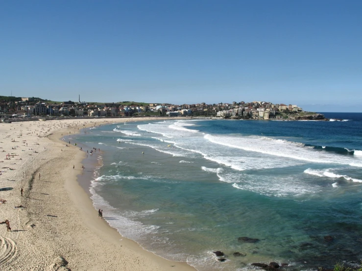 the view of a sandy beach with a city in the background