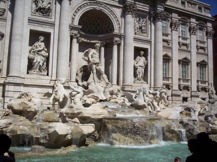 a fountain with two statues next to a building