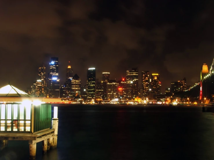 an elevated dock with lights on on the bay bridge in the background