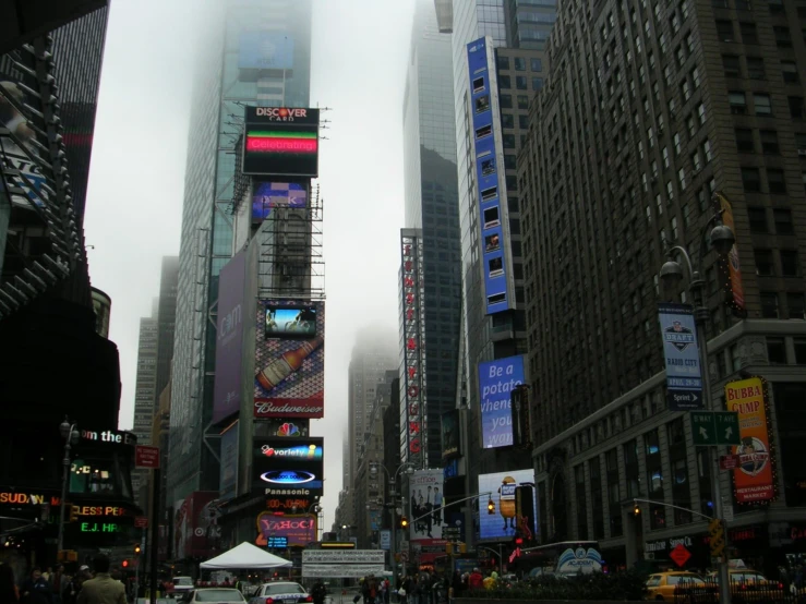 an intersection with tall buildings in the city on a foggy day