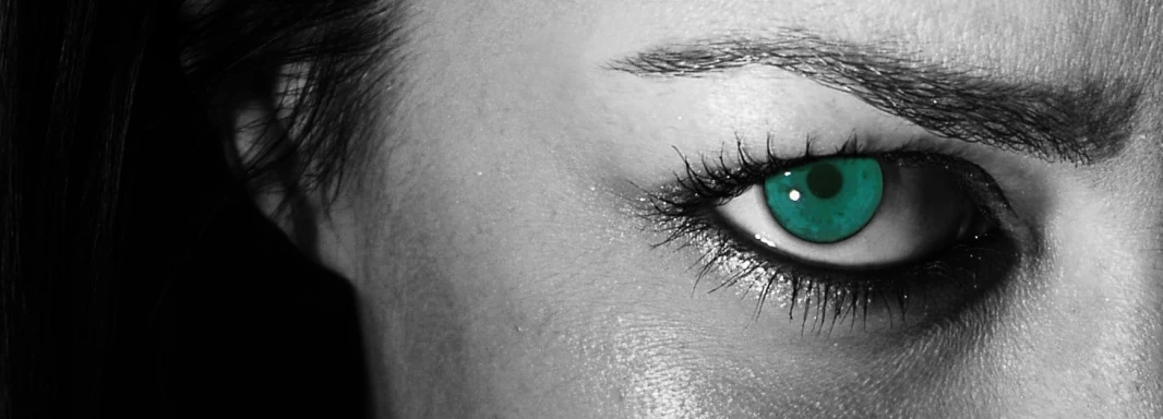 a person with green eyes stares directly at the camera