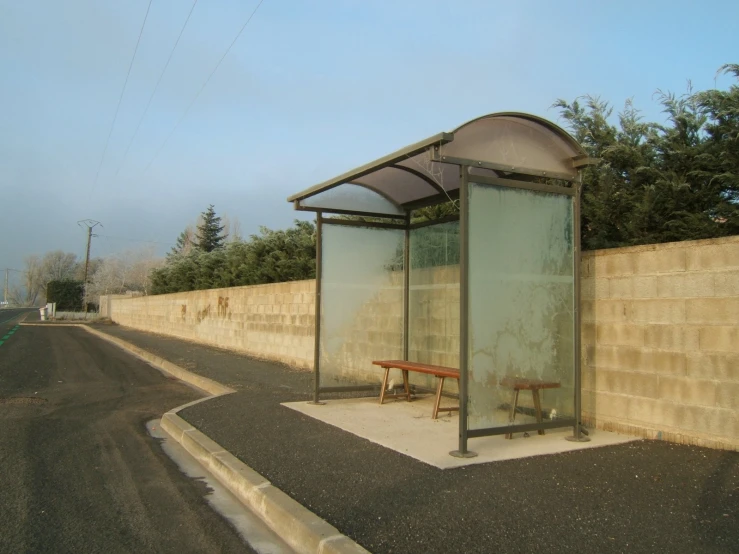 a public transit bus stop next to a cement wall