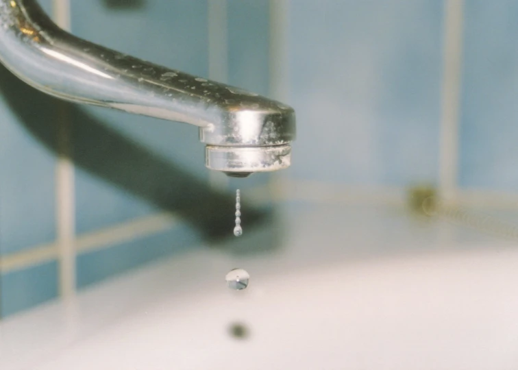 a faucet is spouting water from a chrome sink