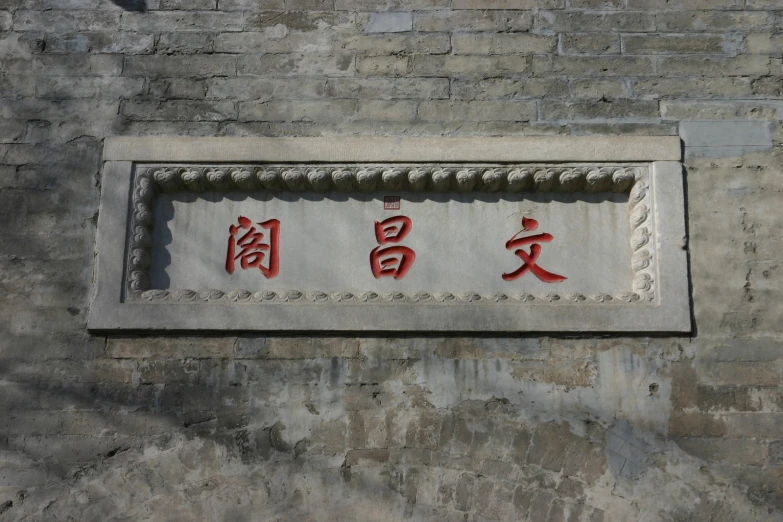 a sign with asian writing that has been designed into a wall