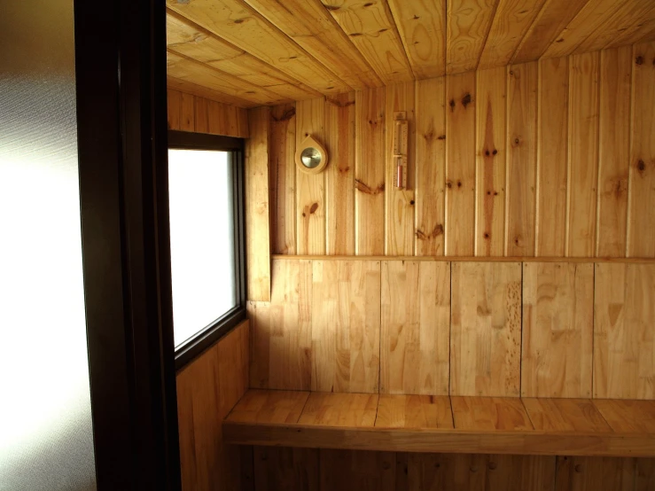a wooden room with sunlight from a window and wood paneling