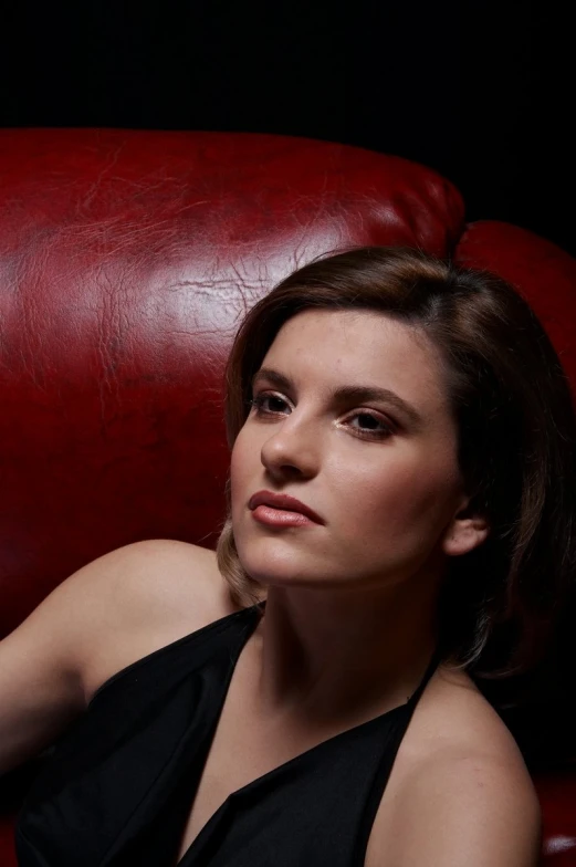 a woman sitting in a red chair looking away