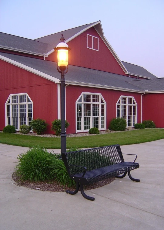 an empty bench in front of a red building