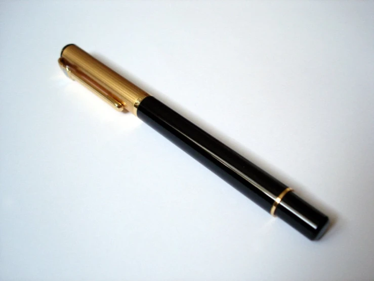 a golden fountain pen and black ink