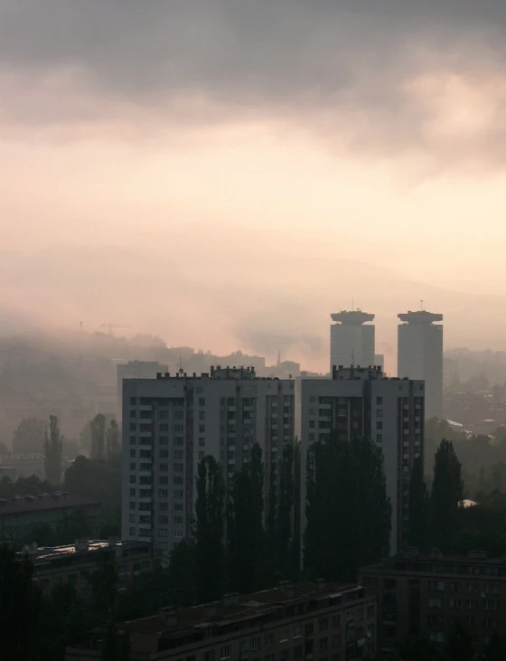 a very cloudy sky over some tall buildings