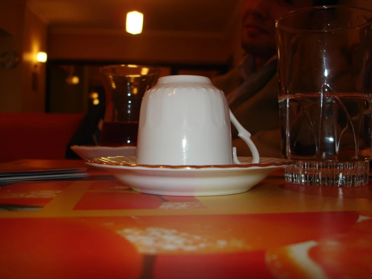 two dishes on a dining room table with glasses and plates