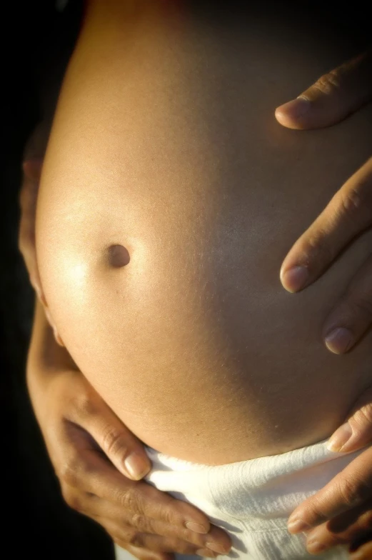 a pregnant belly is shown in the light