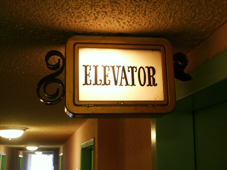 a sign is hanging from the ceiling next to a doorway