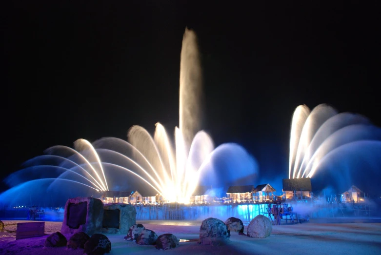 a fountain lit up and showing water splashing