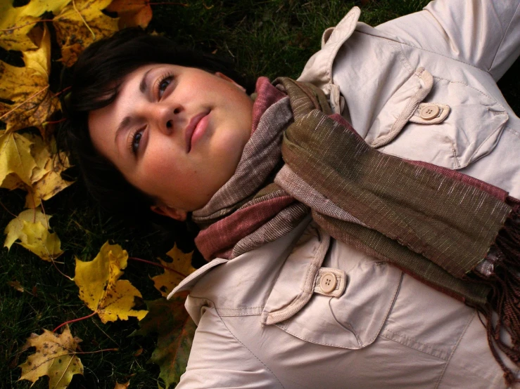 a woman laying on the ground with a leaf on her