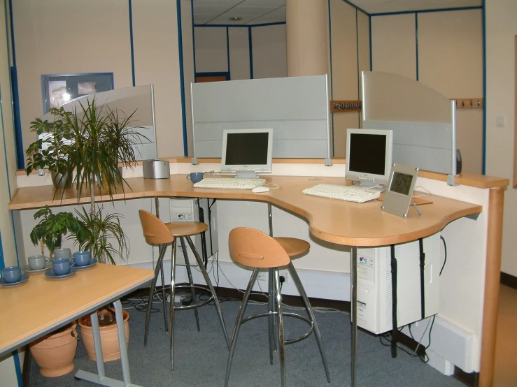 a desk with four computers on the top of it