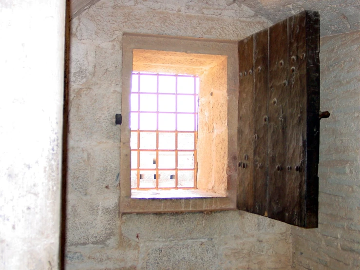 window in a stone wall with bars on top