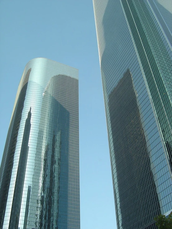 tall buildings are in the sunlight against a blue sky