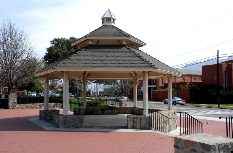 a small covered shelter in the middle of a paved path