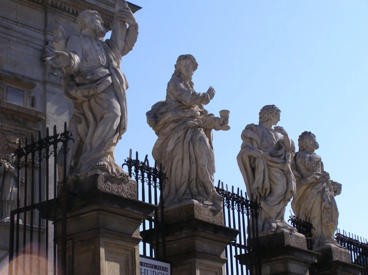 statues outside a building with a sky background