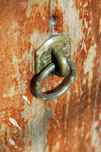 a rusted door knocket with a metal knock latch