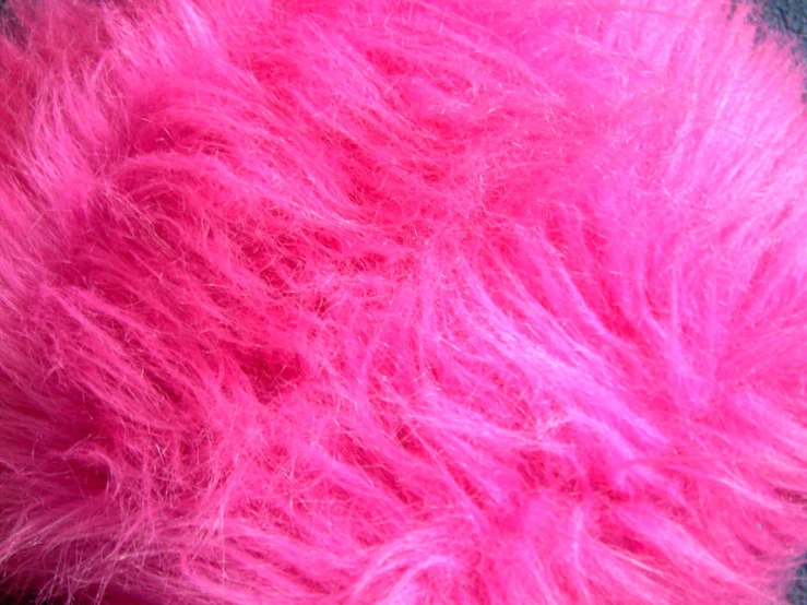 pink fuzzy fur is laying on the floor