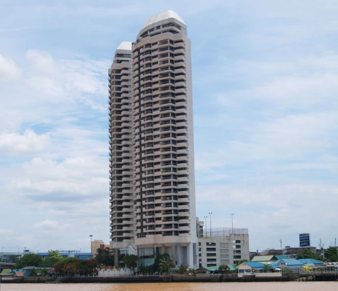 tall building on the edge of the water near a pier