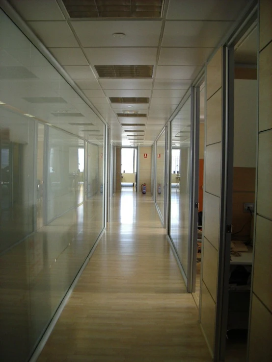 an empty office hallway with doors and no people