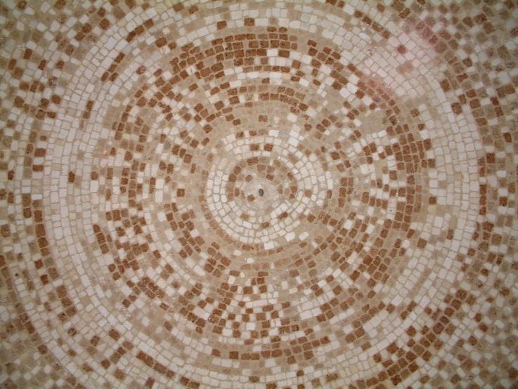 a brown and white mosaic tile with light brown dots