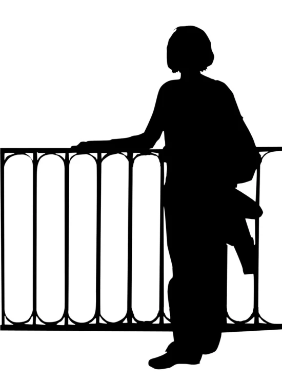 a person in a jacket standing by a railing