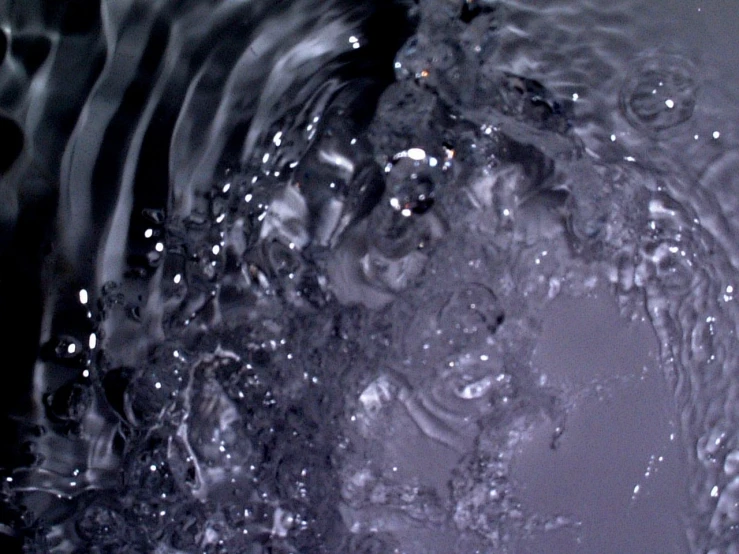 water is flowing over a liquid with some drops