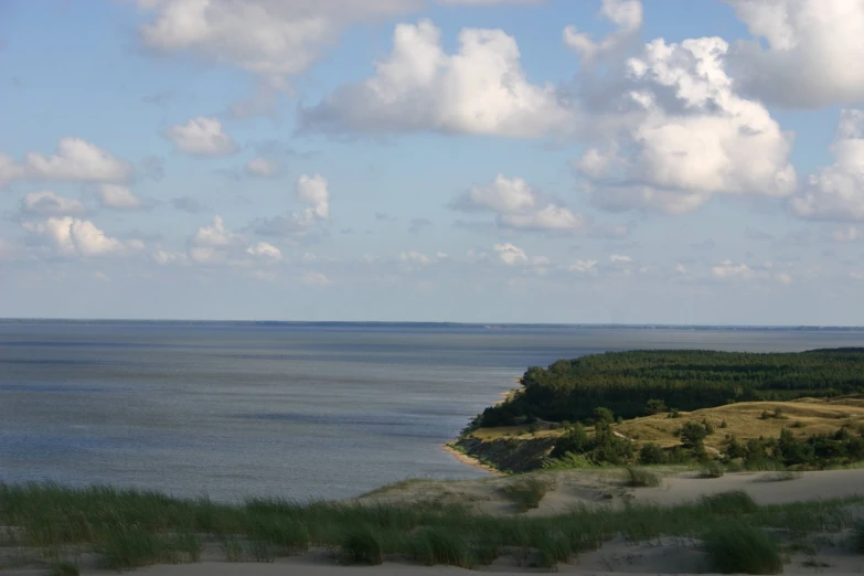 some white clouds over a large blue ocean