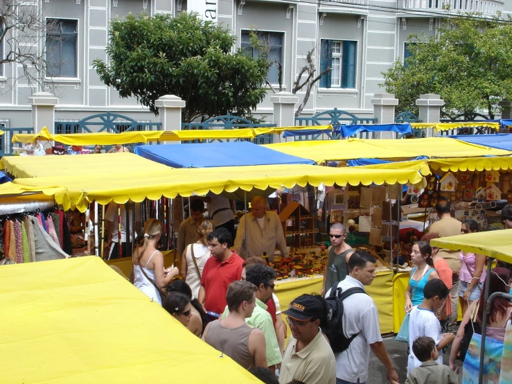 a bunch of yellow umbrellas are out at an outdoor flea market