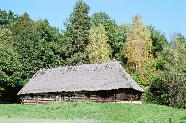 there is a cabin on a hill near the forest