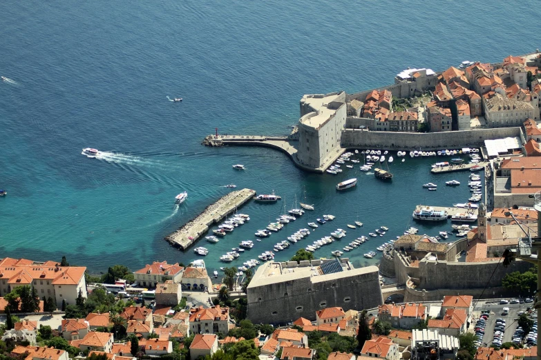 some boats a marina and a building with orange roofs