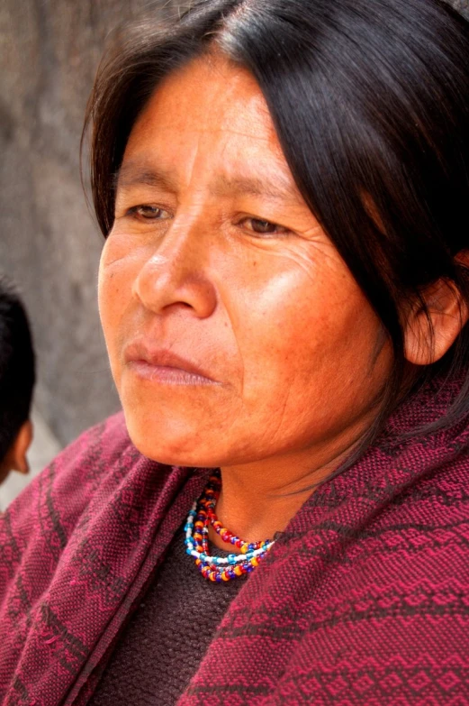 a woman is looking to the left as she wears a scarf