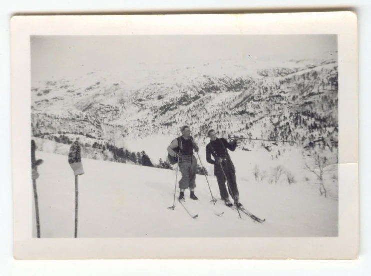 black and white image of three skiers on mountain