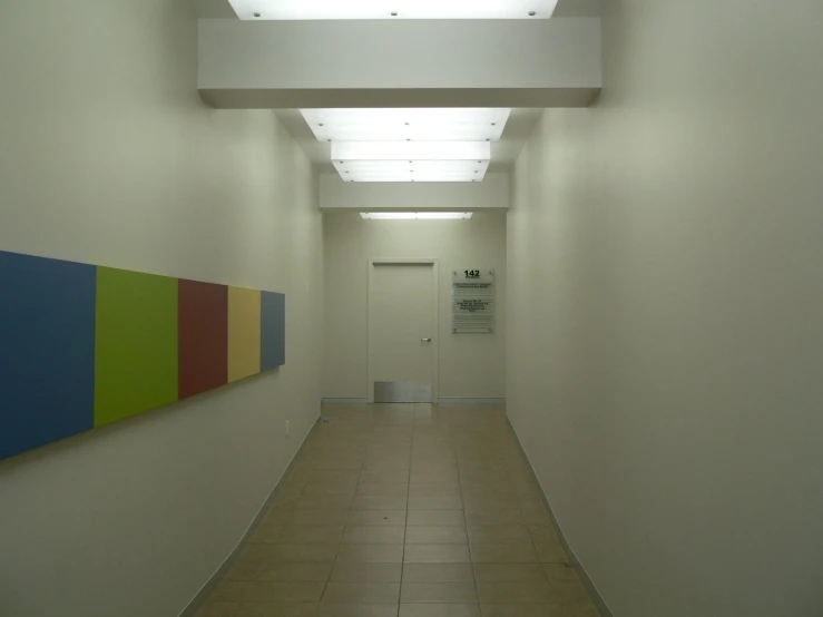 an empty hallway with a wall mounted painting