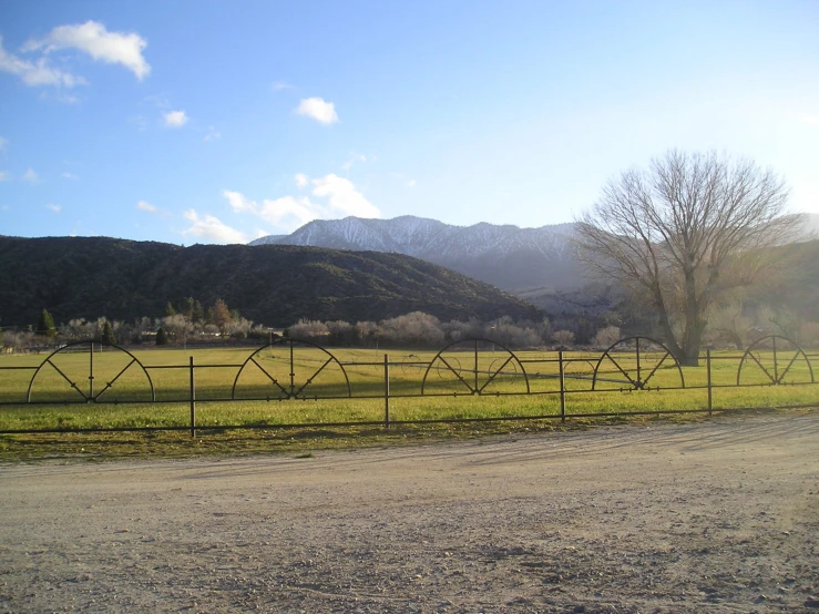 a dirt road in front of a fence