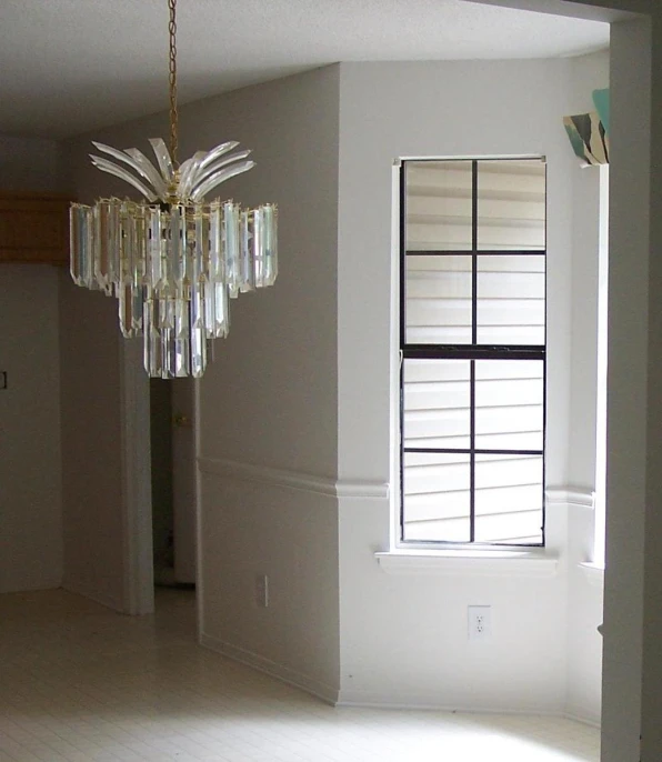 a lamp in a white room with a chandelier